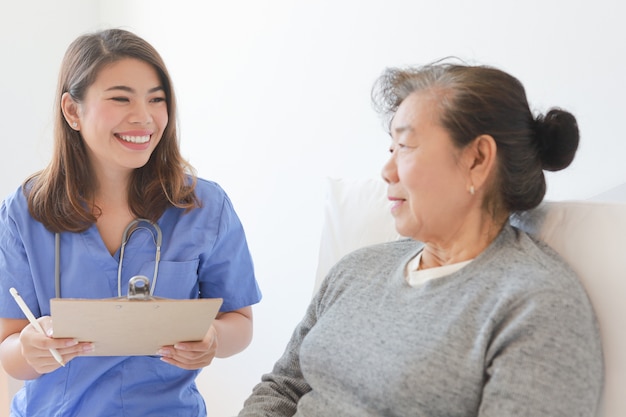 Asian Senior old woman on the bed with doctor and her son in hospital