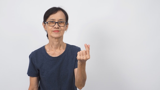 Asian senior or older woman doing miniheart hand sign on white background.