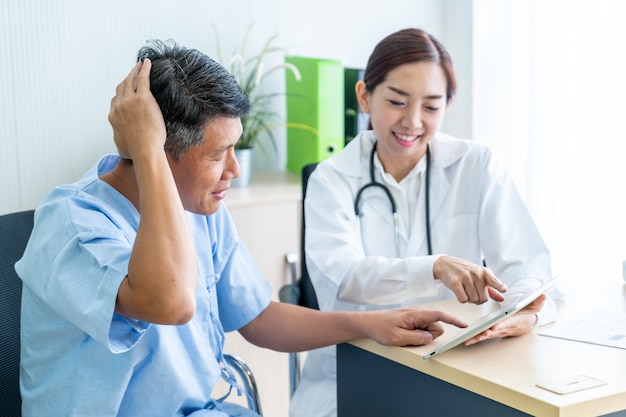 Foto paziente maggiore asiatico che ha consultazione con il medico