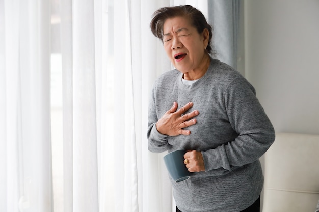 거실에서 심장 손상으로 아픈 아시아 고위 여자 어머니