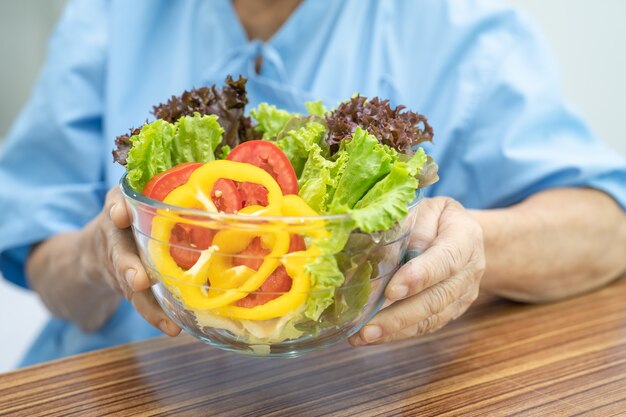 아침 야채 건강 식품을 먹는 아시아 노인 여성 환자