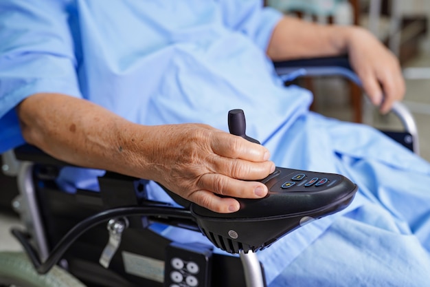 Asian senior woman patient on electric wheelchair in hospital.