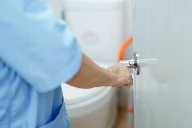 Asian senior woman patient open toilet bathroom by hand in nursing hospital healthy strong medical