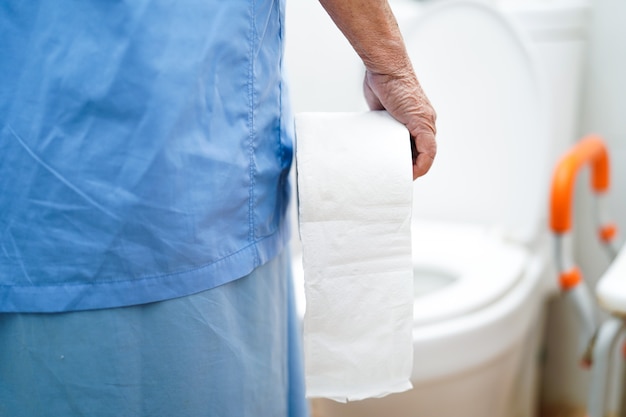 Foto paziente senior asiatico della donna nella toilette con il tessuto nel reparto di ospedale di professione d'infermiera