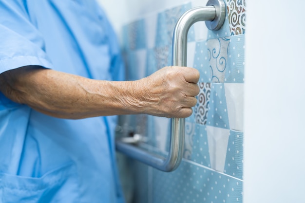 Asian senior woman patient use toilet bathroom handle security