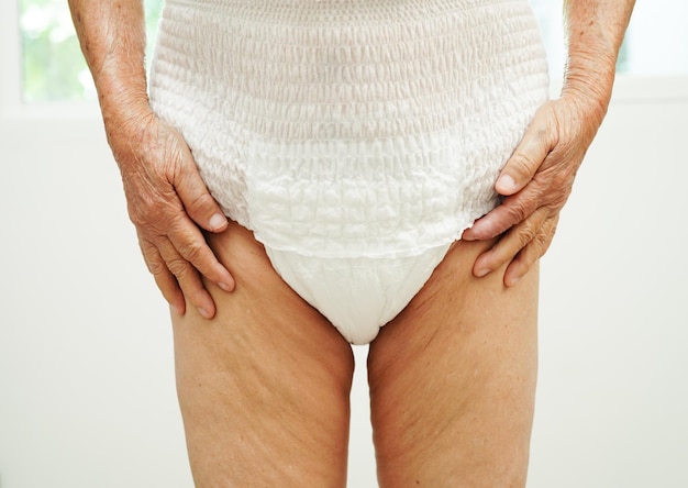 Asian senior woman patient wearing adult incontinence diaper pad in hospital