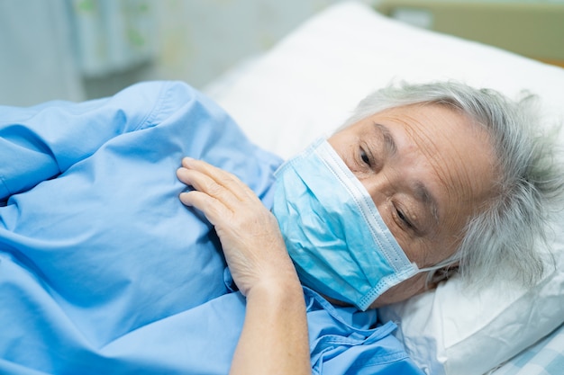 Asian senior woman patient wearing a face mask in hospital for protect from Coronavirus