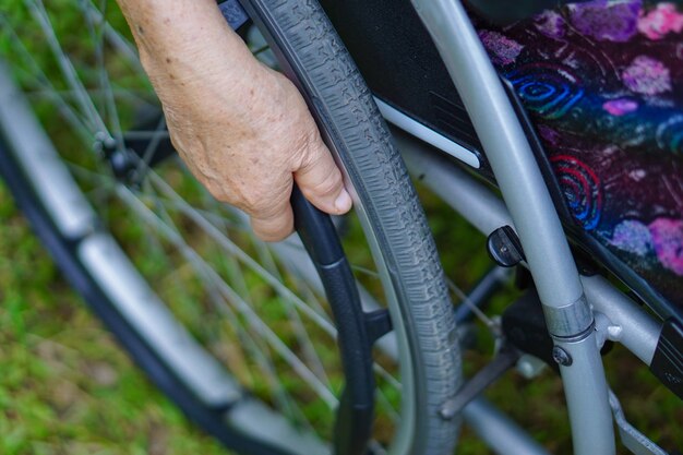 Foto paziente senior asiatico della donna sulla sedia a rotelle in parco.