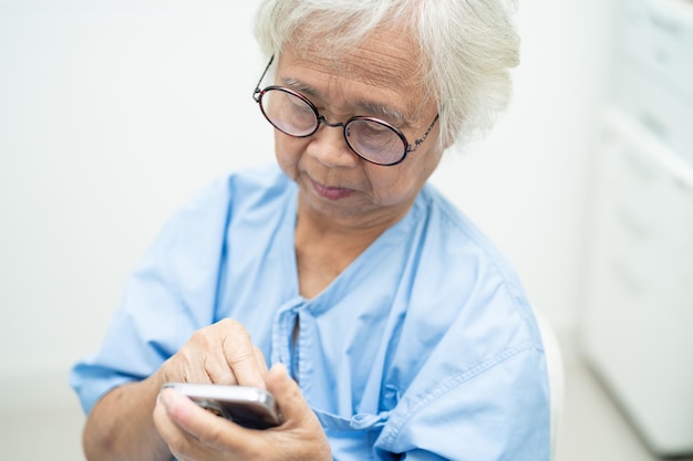 Asian senior woman wearing eyeglasses use mobile phone