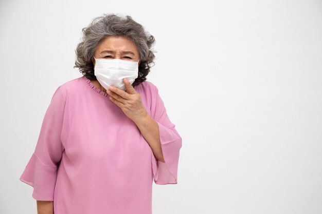 Donna senior asiatica che indossa una maschera protettiva per coronavirus della peste