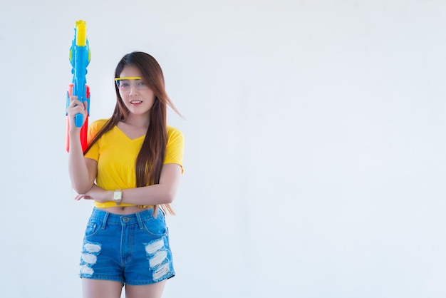 Photo asian sexy woman with gun water in hand on white backgroundfestival songkran day at thailandthe best of festival of thailand of smile