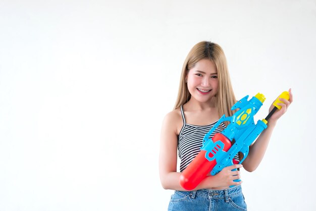 Asian sexy woman with gun water in hand on white backgroundFestival songkran day at thailandThe best of festival of thaiLand of smile