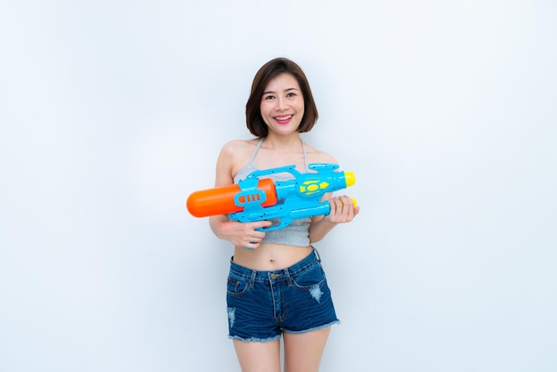 白い背景に銃の水を手にしたアジアのセクシーな女性タイでのフェスティバルソンクランデータイの最高のフェスティバル笑顔の土地
