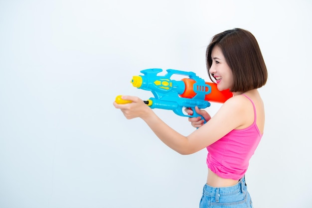 Asian sexy woman with gun water in hand on white backgroundFestival songkran day at thailandThe best of festival of thaiLand of smile