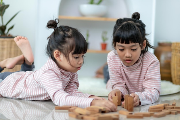 家で木製のスタックを再生するアジアの兄弟の女の子