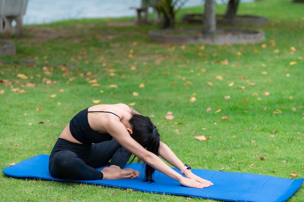 Asian slim woman exercise alone in the parkTired from workoutPlay yoga concept