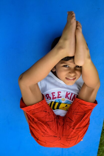 Asian smart kid doing yoga pose in the society park outdoor childrens yoga pose the little boy