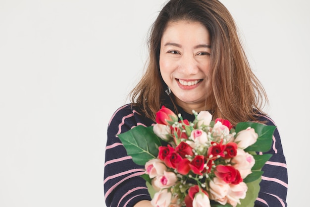 Asian smiling  woman on gray studio shot with red rose flower.