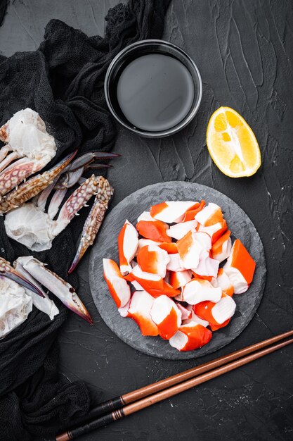 Asian snack surimi set, on stone board, on black background, top view flat lay