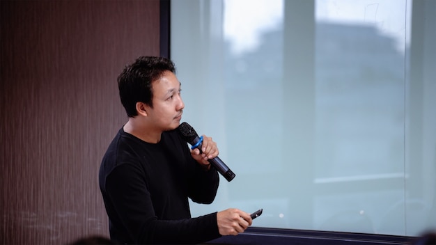  Asian Speaker or lecture with casual suit on the stage in front of the room 