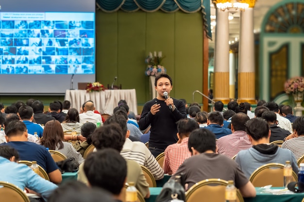 Asian Speaker with casual suit standing and giving the knowledge with audience in the conf