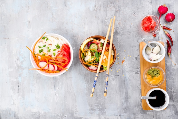 Asian spicy salad of glass noodles or funchoza with carrots and vegetables salad on stone background