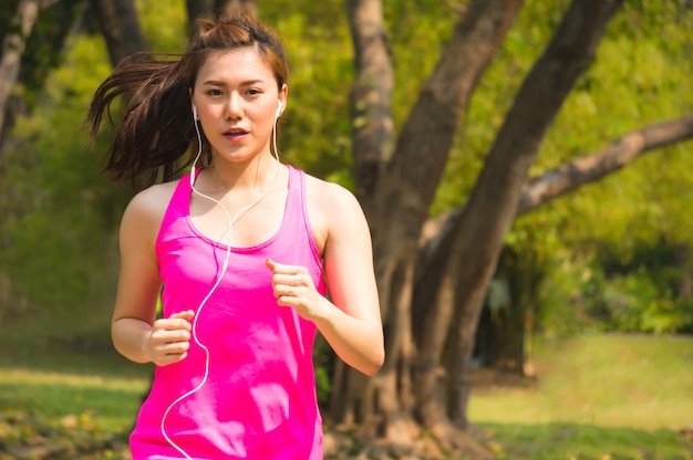 Donna asiatica di sport che pareggia, che corre nel parco