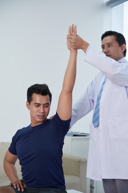 Asian Sportsman Getting Physiotherapy At Clinic