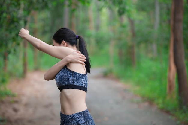 Asian sporty woman stretching body breathing fresh air in the parkThailand peopleFitness and exercise conceptJogging in the parkWarm up bodySit for Lace up shoes