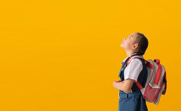 Photo asian student cute little girl wears school uniform nicelooking lovely attractive curious creative isolated on yellow background with clipping paths for design work empty free spacee