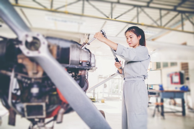 Азиатский студент Инженеры и техники ремонтируют самолет по классу в университете