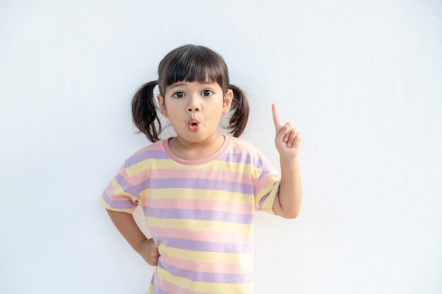 Asian student girl over white background pointing finger up with a successful idea. Excited and happy. Number one.