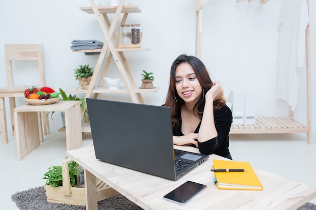 Фото Азиатская студентка женщина учится онлайн-образованию молодая женщина делает домашнее задание с портативным компьютером