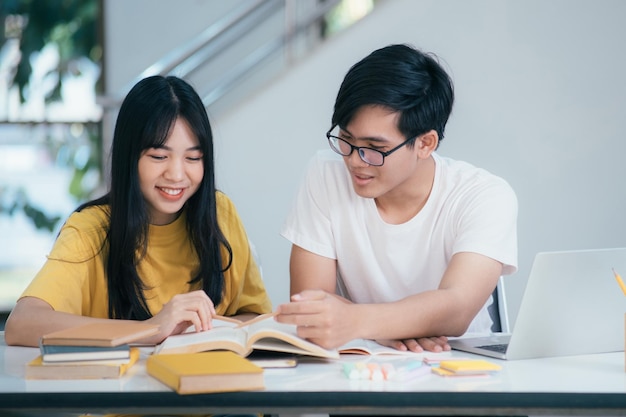 Photo an asian students are reading books and study tutoring together