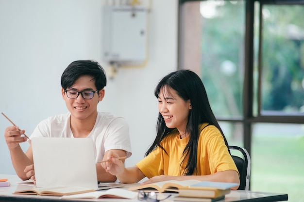 アジアの学生が本を読んで、一緒に家庭教師を勉強している