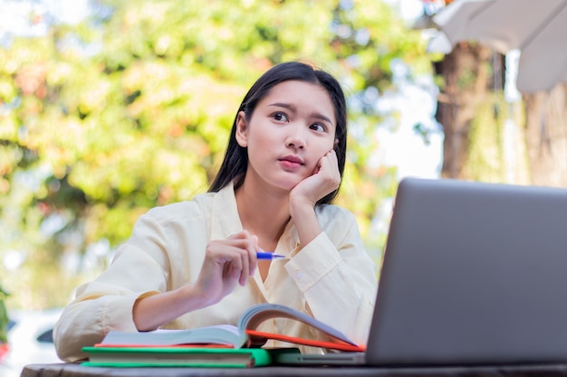 Asian students. Happy cheerful young asian woman smiling and using laptop in cafe 