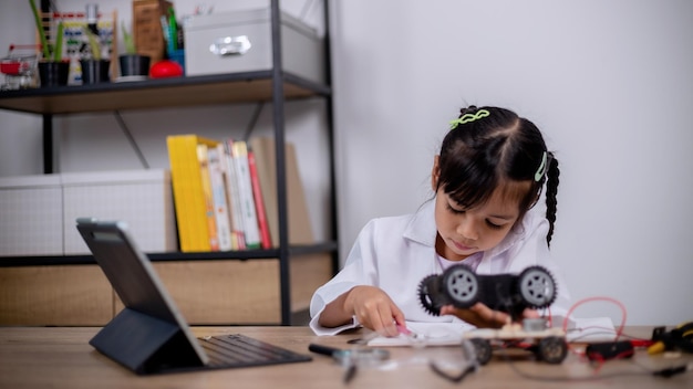 사진 아시아 학생들은 stem에서 로봇 자동차와 전자 보드 케이블을 코딩하여 집에서 배웁니다. steam 수학 공학 과학 기술 어린이 개념을 위한 로봇 공학에서 컴퓨터 코드