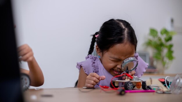 アジアの学生は、STEM STEAM でロボットカーと電子基板ケーブルをコーディングすることで自宅で学習します 数学 工学 科学技術 コンピュータコード ロボット工学で子供の概念