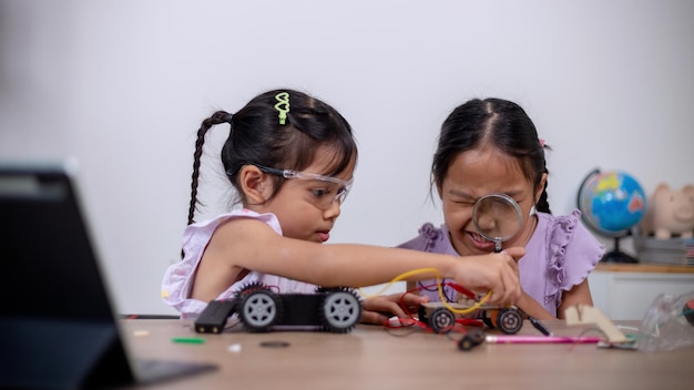 Asian students learn at home by coding robot cars and electronic board cables in STEM STEAM mathematics engineering science technology computer code in robotics for kids' concepts