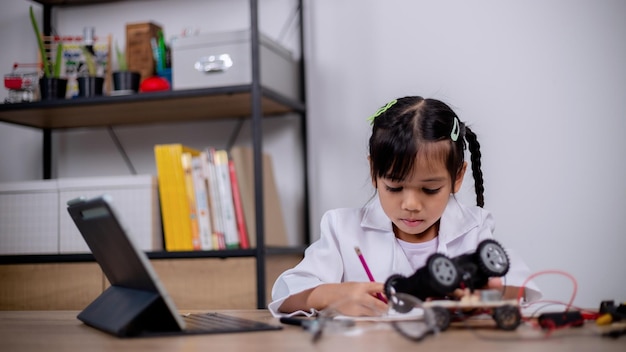 アジアの学生は、STEM STEAM でロボットカーと電子基板ケーブルをコーディングすることで自宅で学習します 数学 工学 科学技術 コンピュータコード ロボット工学で子供の概念