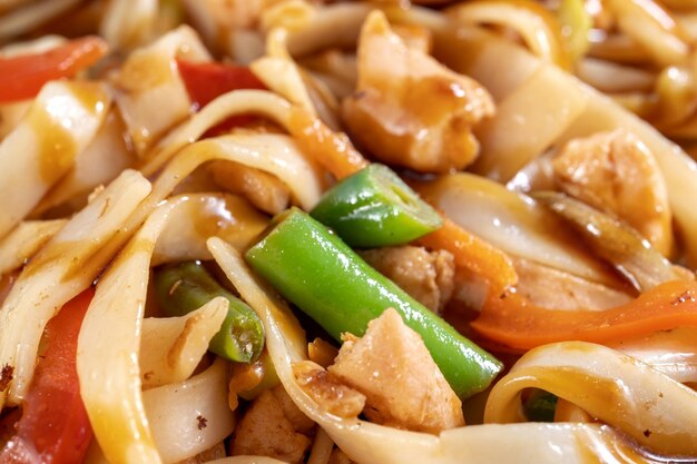 Asian style stirfry vegetables in chicken wok Poured with sauce large pieces of chicken are visible