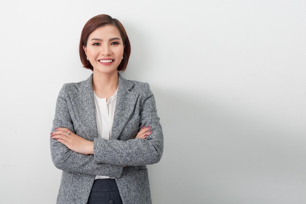 Asian successful confident young businesswoman with arms crossed isolated in white background