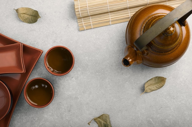 Asian tea concept two cups of tea and a teapot top view