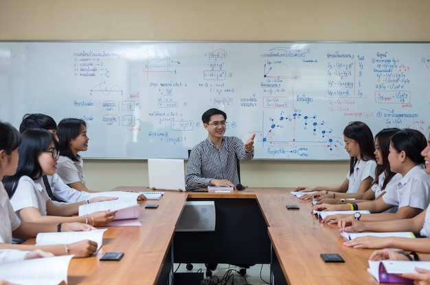 Asian teacher Giving Lesson to group of College Students in the classroom