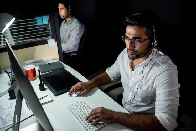 Squadra di supporto tecnico asiatico turno notturno di lavoro in call center