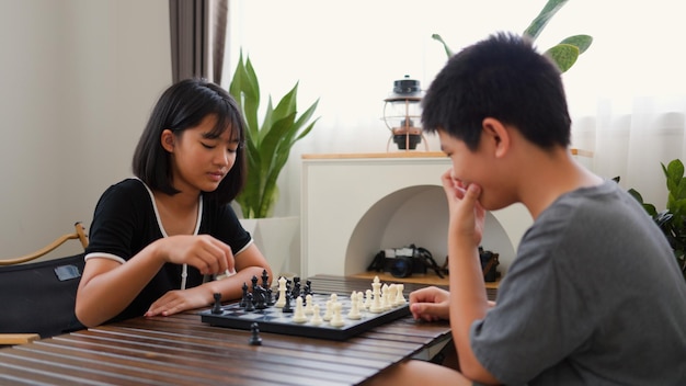 アジアの10代の少年と少女が自宅でチェスをしている 戦略的思考論理集中力 脳トレーニングの概念 青年教育 室内ボードゲーム活動