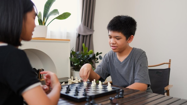 アジアの10代の少年と少女が自宅でチェスをしている 戦略的思考論理集中力 脳トレーニングの概念 青年教育 室内ボードゲーム活動