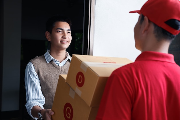 Asian teenager accept supplies at door, after covid-19 outbreak end the people still shopping via online.