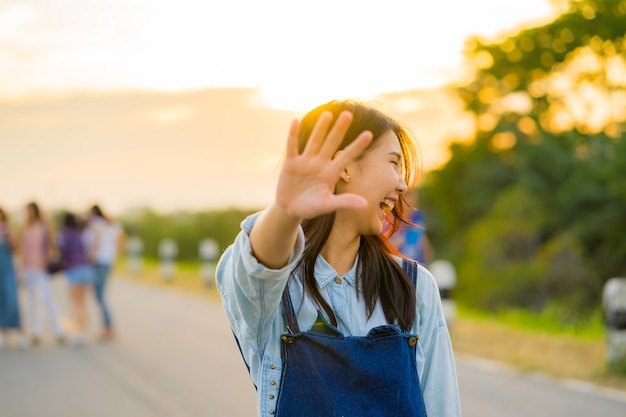 Asian teenager girl raising her right arm 