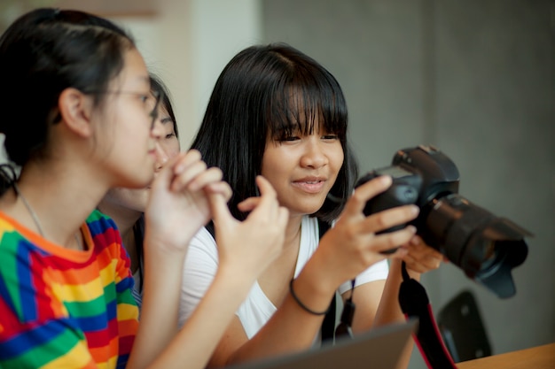 Азиатский подросток, глядя на задний экран камеры dslr в руке
